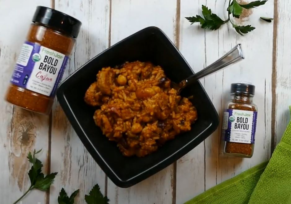 Bowl of Jambalaya next to Cajun Seasonings