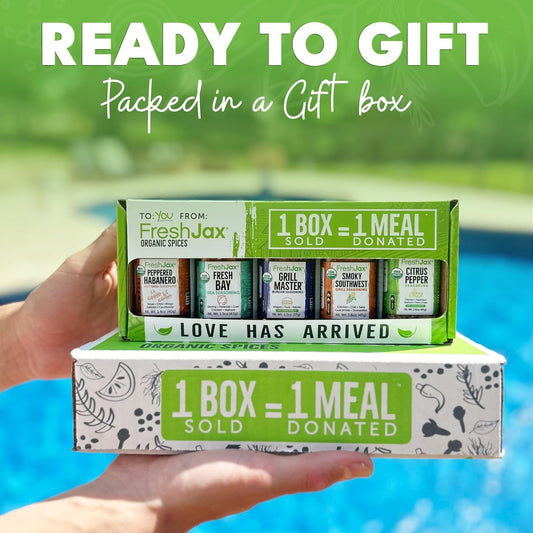 A pair of hands holding two FreshJax gift boxes in front of a blue swimming pool. The graphic reads "Ready to Gift - Packed in a Gift Box" and emphasizes the social mission: "1 Box = 1 Meal Sold / Donated."