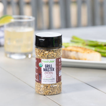 Grill Master Steak Seasoning next to salmon, asparagus, and a beverage