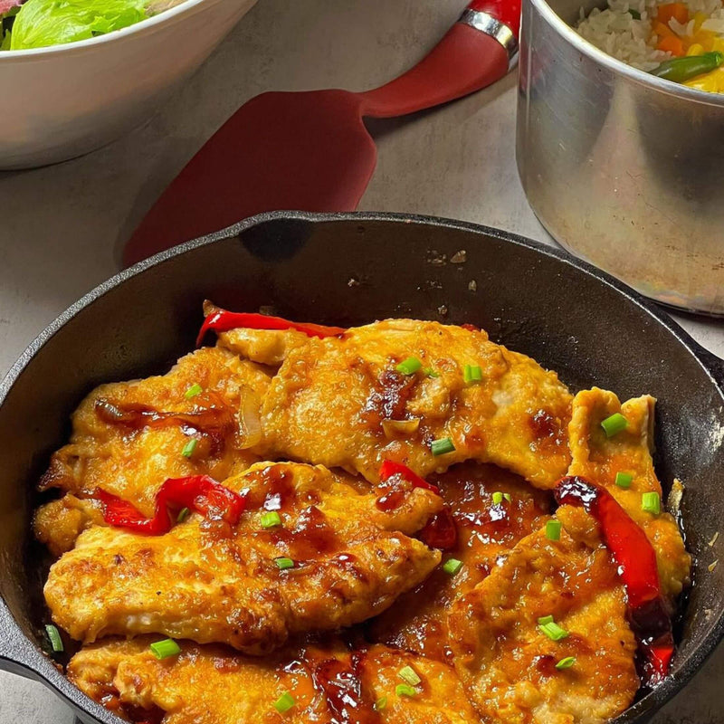 Apricot Chicken in a pan near a side salad