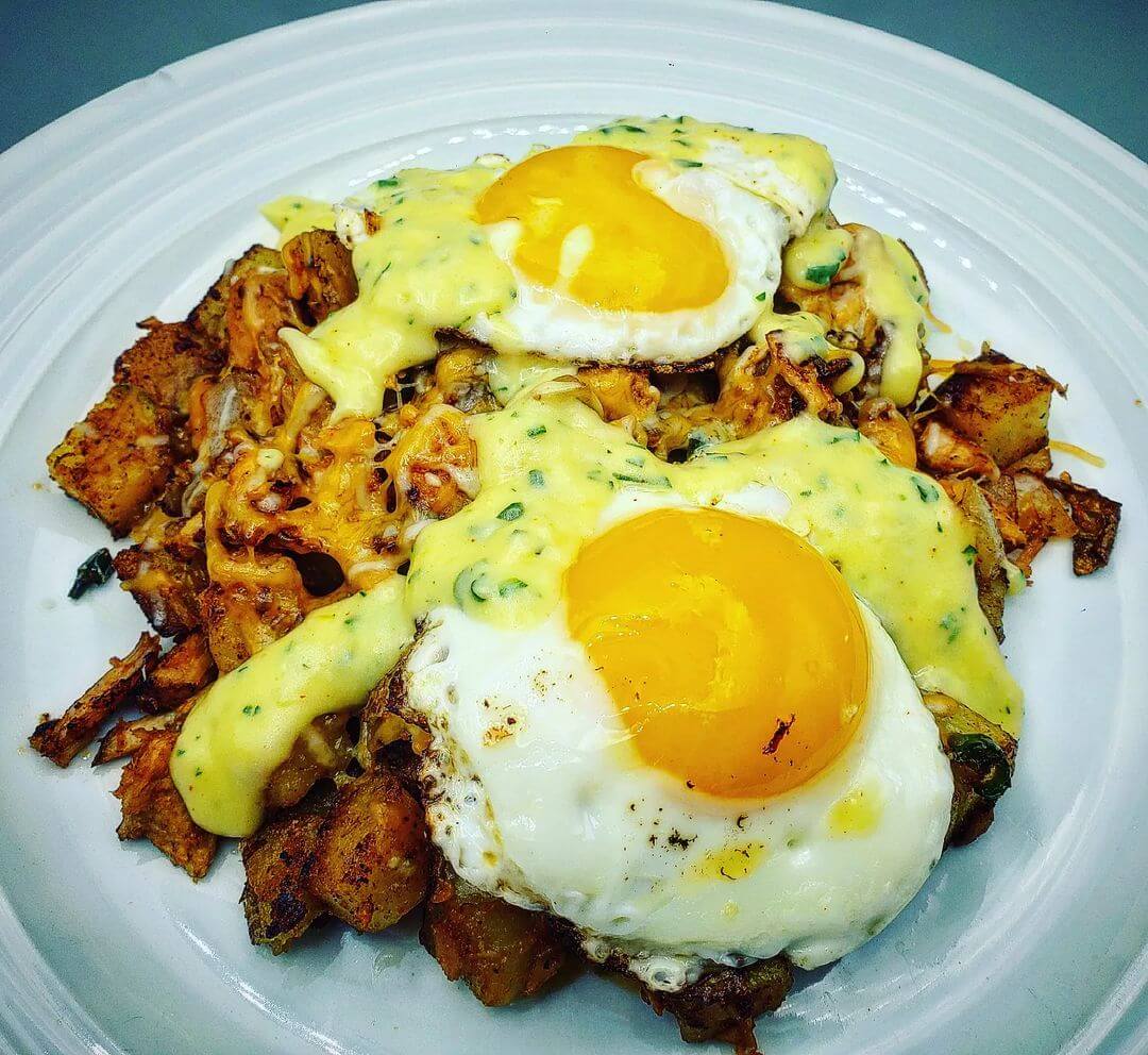 Hashbrowns covered in Hollandaise Sauce, eggs, and pulled pork 