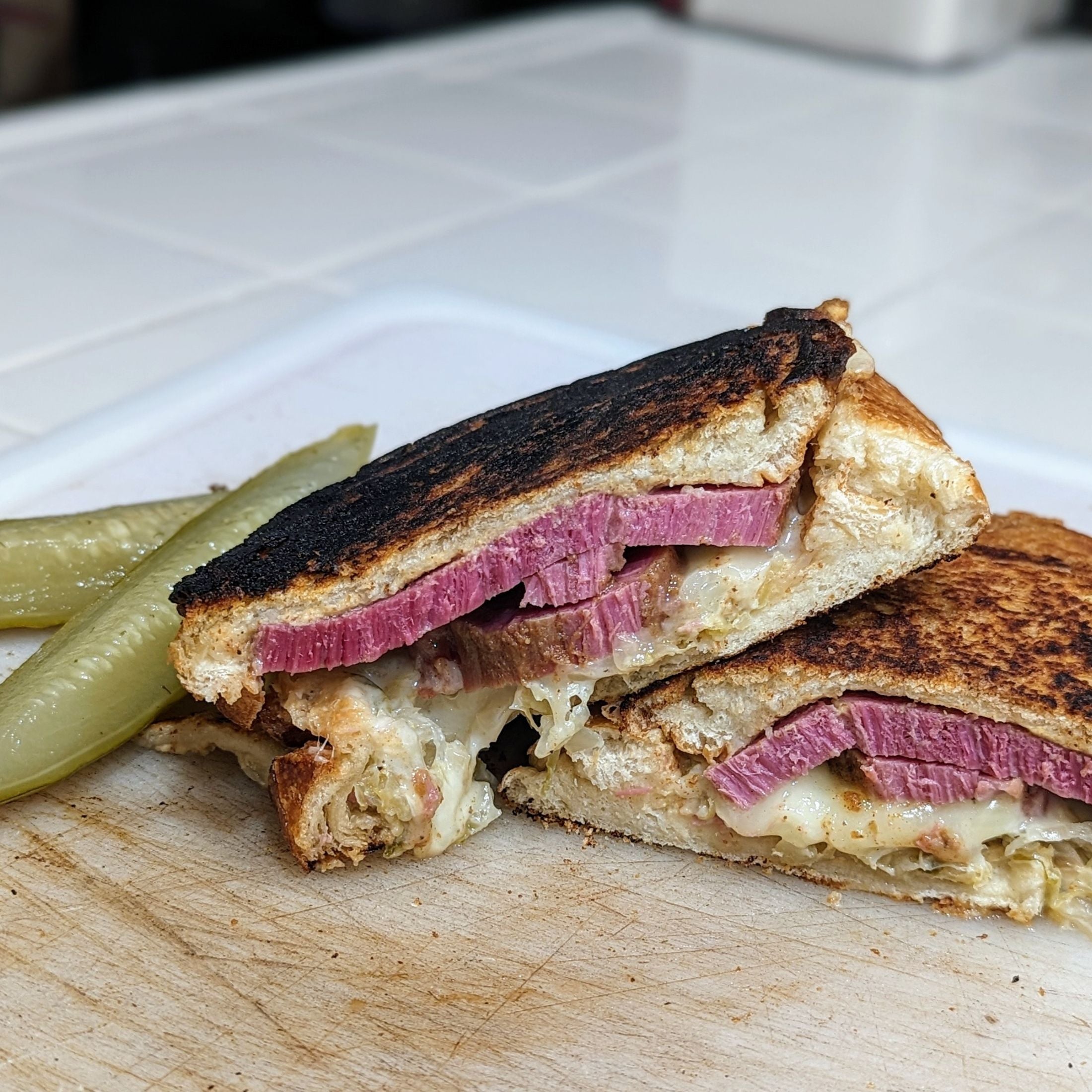 Smoked Corn Beef Sandwich on a cutting board with pickles
