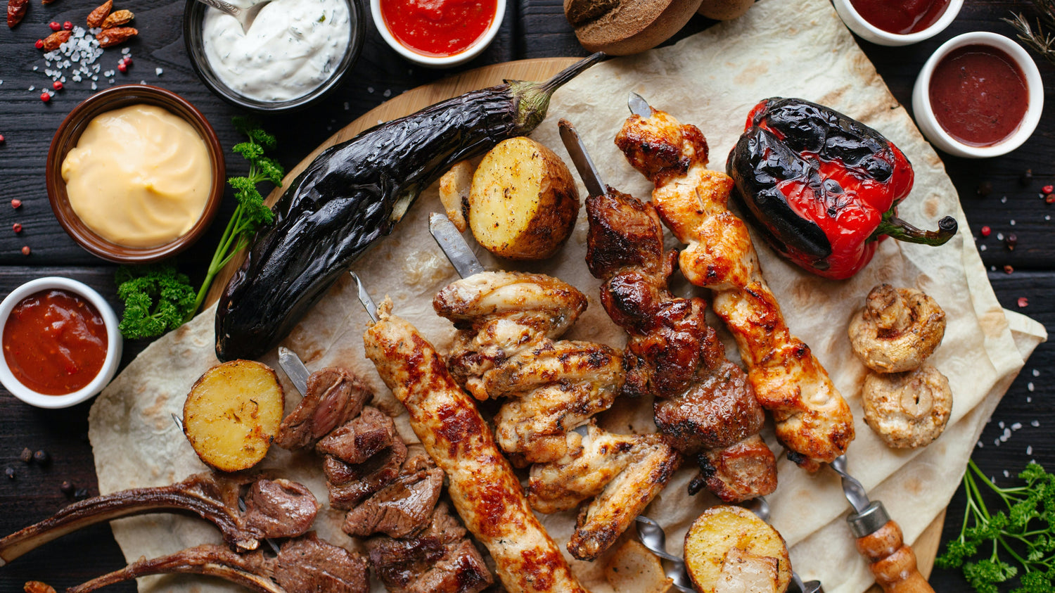 Kebabs Surrounded by Greek Seasonings and Sauces