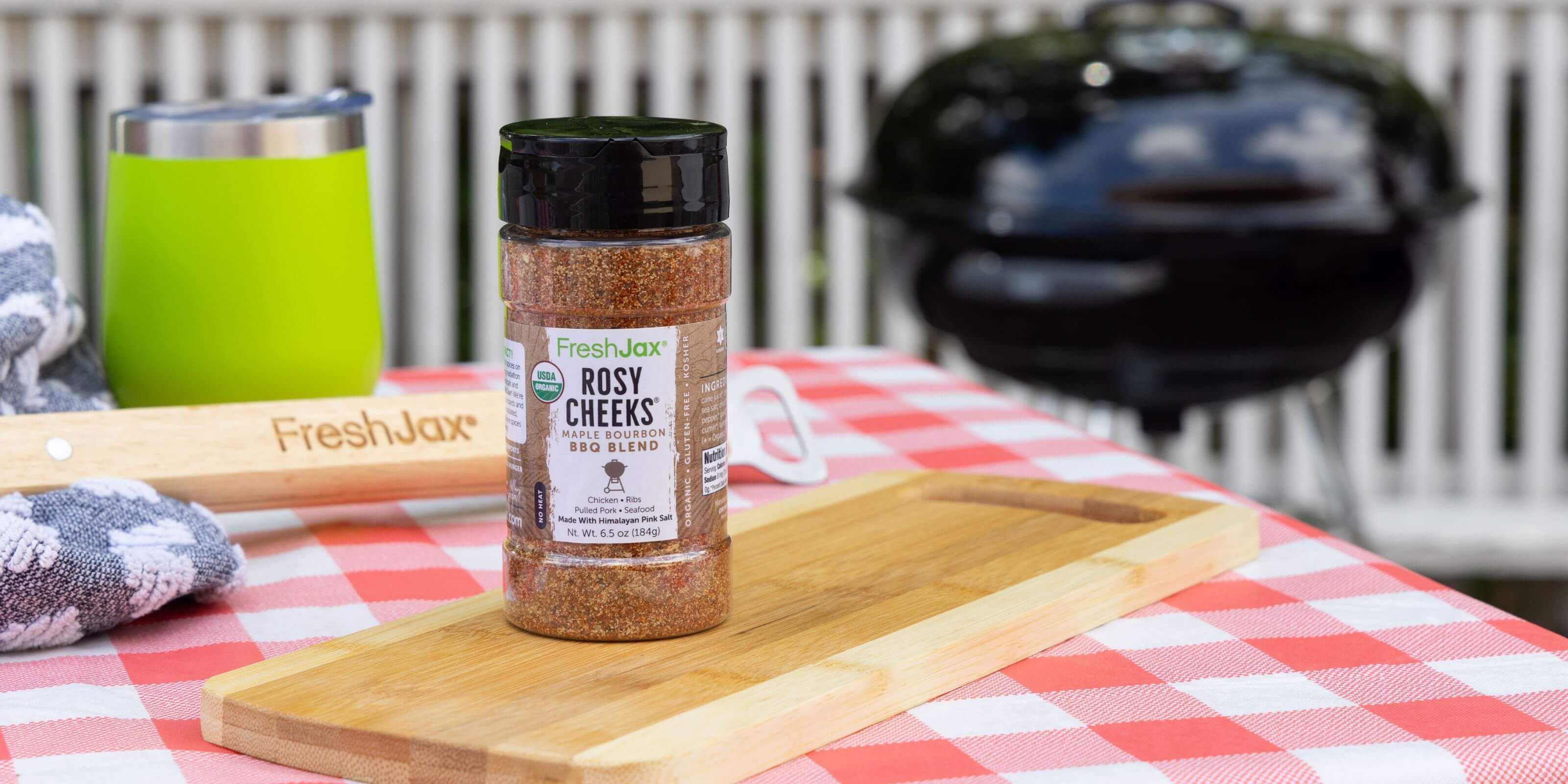Rosy Cheeks Maple Bourbon BBQ Rub on a Picnic table next to a grill