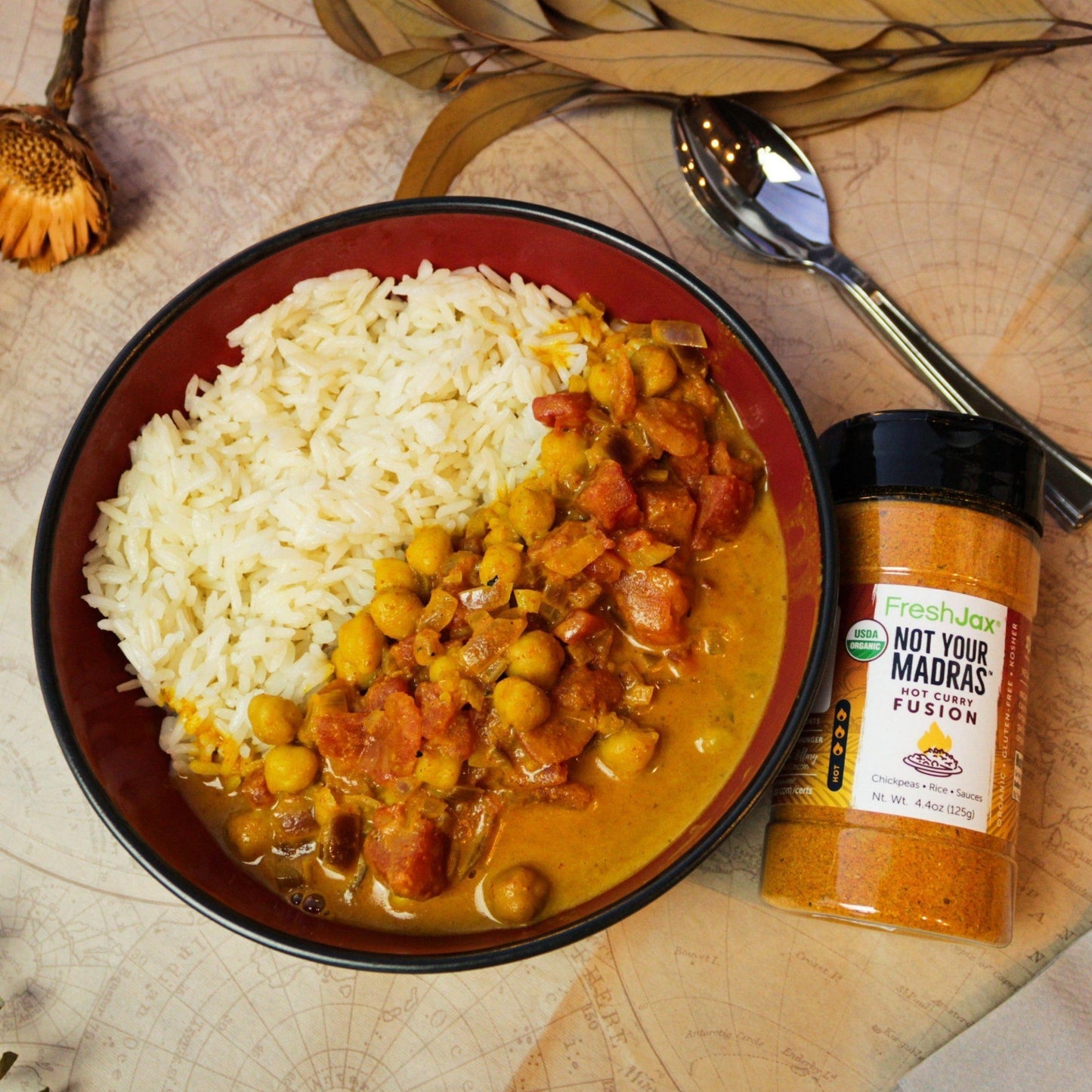 FreshJax Organic Spices Not Your Madra's™: Organic Hot Red Curry Fusion next to a bowl of chickpea curry